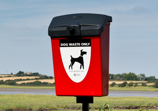 Fido™ 25L Outdoor Dog Waste Bin in red with dog waste only graphic, post mounted in public field