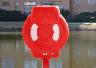 Guardian™ Lifebuoy Housing in red with white panelling, situated by large pond and services building