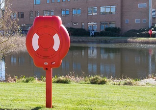 Guardian™ Lifebuoy Housing with life ring in red by campus building and lake