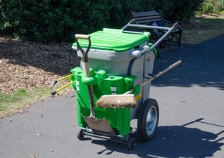 Single Space-Liner™ Orderly Barrow street cleaning trolley in grey with green moulding and lid and litter grabber and broom on public footpath