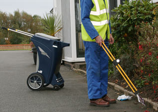 Skipper™ Cleaning Trolley in navy blue with handles and man using litter grabber